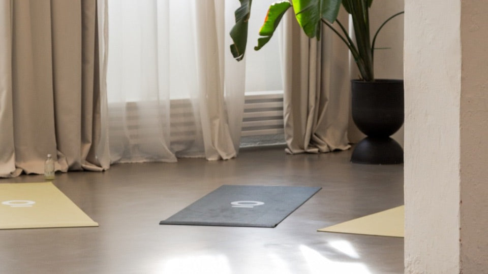 Yogaraum, der warmes Licht, Pflanzen und Yogamatten zeigt