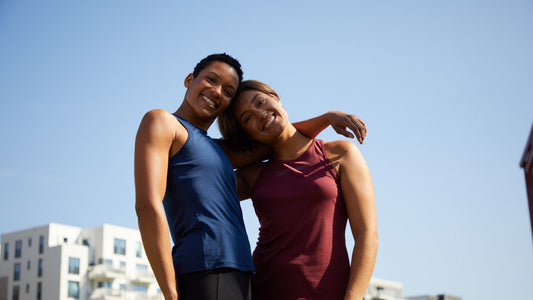 Confident and happy women in GOODEN Sportswear smiling at the camera with blue sky in the background.