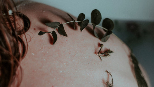 Woman having plants on her back skin what is a symbol to show the nutritious impact the seaweed can have for the skin