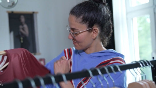 Designerin Jasmin is holding her self designed T-shirt while she shows why she designed it like this.