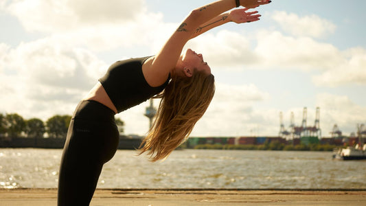 Woman in sustainable GOODEN Sportswear doing Yoga in the sun.